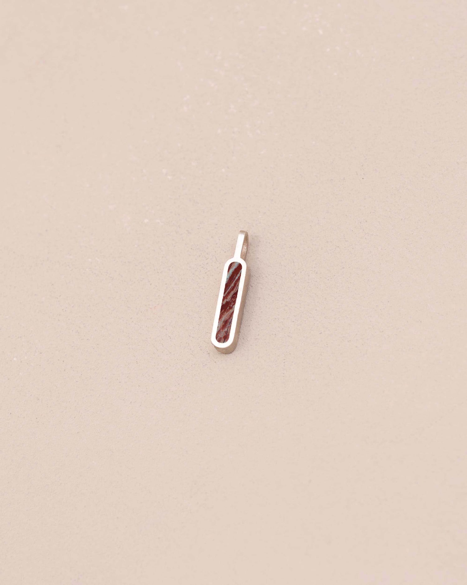Small pendant with a textured design on a beige background