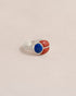 A silver ring featuring a scarab design with lapis lazuli and red jasper inlays, displayed against a neutral background.