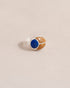 A silver ring featuring a scarab design with lapis lazuli and yellow opal inlays, displayed against a neutral background.