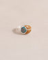 A silver ring featuring a scarab design with starry opal and yellow opal inlays, displayed against a neutral background.