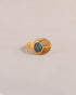 A gold ring featuring a scarab design with starry opal and yellow opal inlays, displayed against a neutral background.