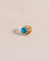 A silver ring featuring a scarab design with turquoise and yellow opal inlays, displayed against a neutral background.