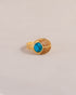 A gold ring featuring a scarab design with turquoise and yellow opal inlays, displayed against a neutral background.