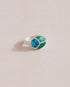 A silver ring featuring a central turquoise stone flanked by malachite stones on either side, set against a neutral background.