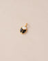 A small gold charm featuring a black and white opal scarab design.