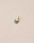 A small gold charm featuring a scarab design with opal and turquoise inlays, displayed against a neutral background.