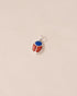 A silver-colored charm with a lapis lazuli and red jasper design, attached to a small silver chain.