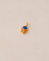 A gold charm featuring a scarab design with a blue lapis lazuli stone in the center, set against a neutral background.