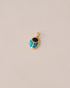 A 14K yellow gold charm featuring a scarab design with onyx and turquoise inlay, displayed against a neutral background.