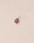 A silver charm featuring a starry opal and red jasper design, resembling a scarab amulet.