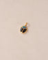 A 14K yellow gold charm featuring a starry opal and onyx design, resembling a scarab amulet.