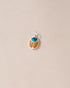 A silver charm featuring a turquoise and mookaite stone in the shape of a scarab amulet.