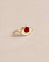 A 14K yellow gold ring with a carnelian stone shaped like an eye, placed on a light background.