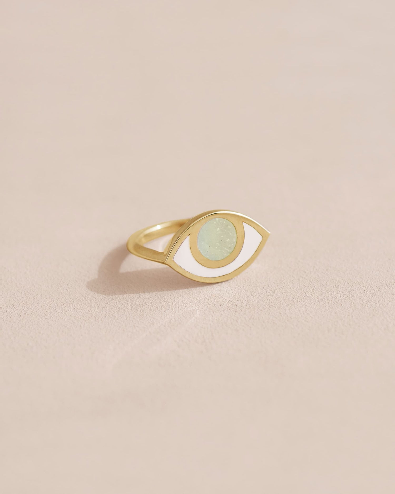 A 14K yellow gold ring with an opal in the shape of an eye set on a neutral background.