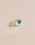 A 14K yellow gold ring with a turquoise stone shaped like an eye, placed against a neutral background.