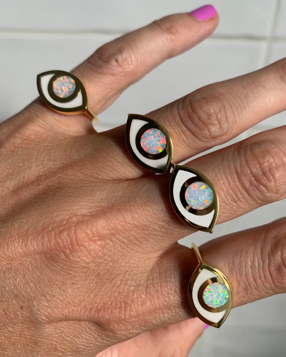 Four eye shaped rings worn by a hand