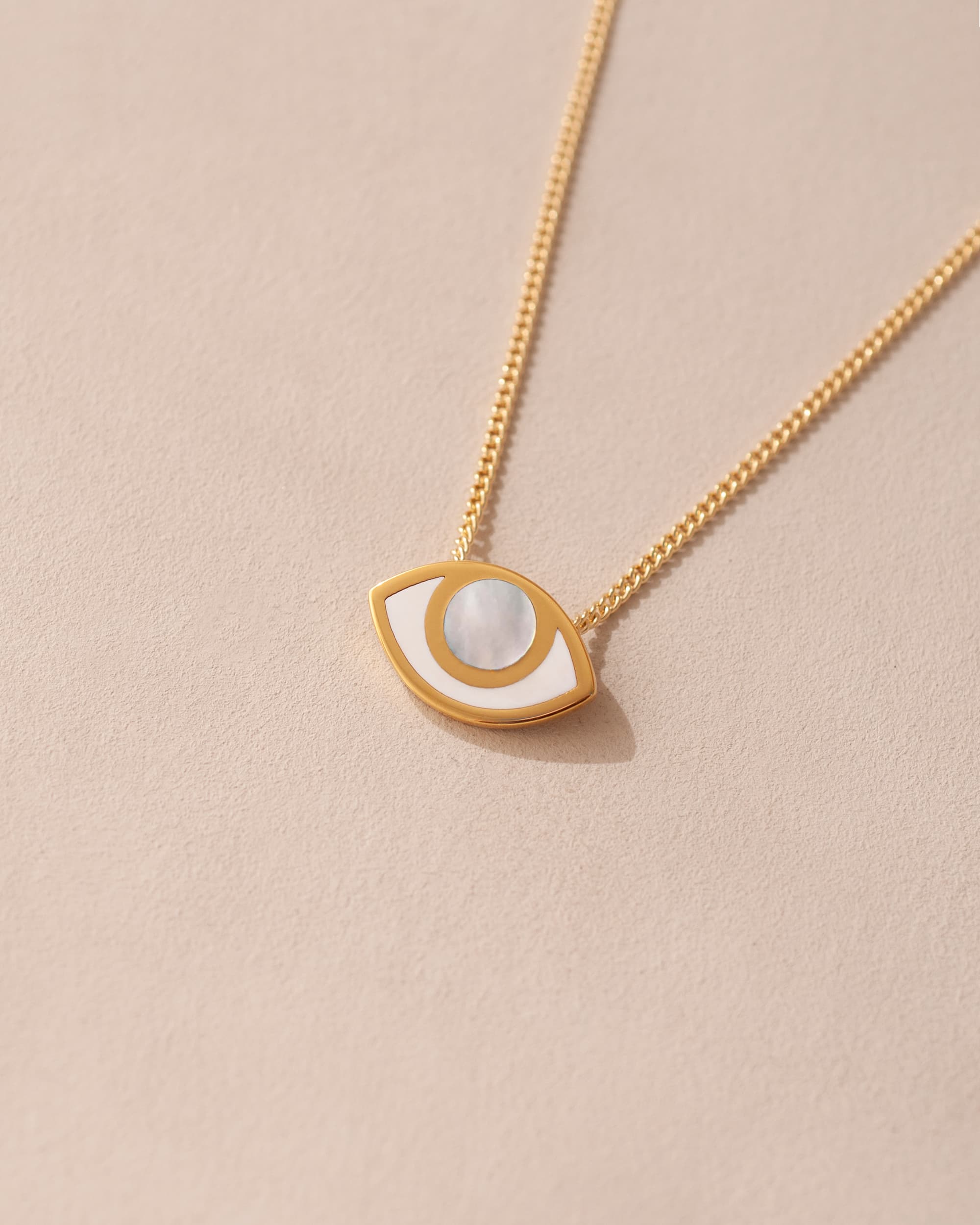 gold eye pendant inlaid with mother of pearl with gold chain