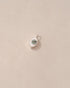 A silver charm with a labradorite stone in the shape of an eye, placed on a beige background.