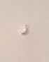 A small silver-colored charm in the shape of a eye, placed on a beige background.