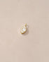 A small porcelain charm in the shape of an eye, set in a 14K yellow gold mounting, displayed against a light background.