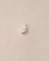a silver charm shaped like an eye featuring a round mother of pearl center