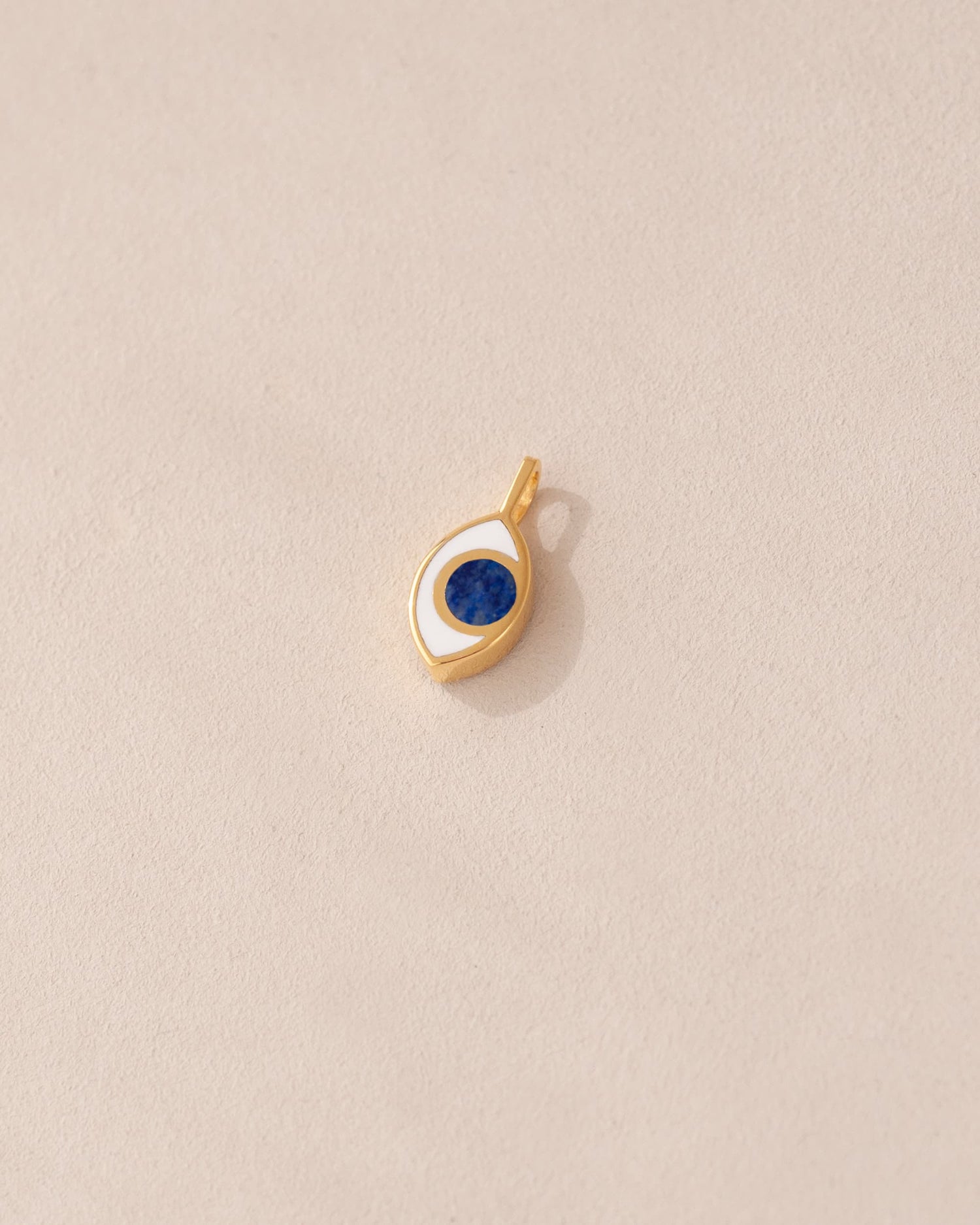 gold charm shaped like an eye with lapis lazuli center