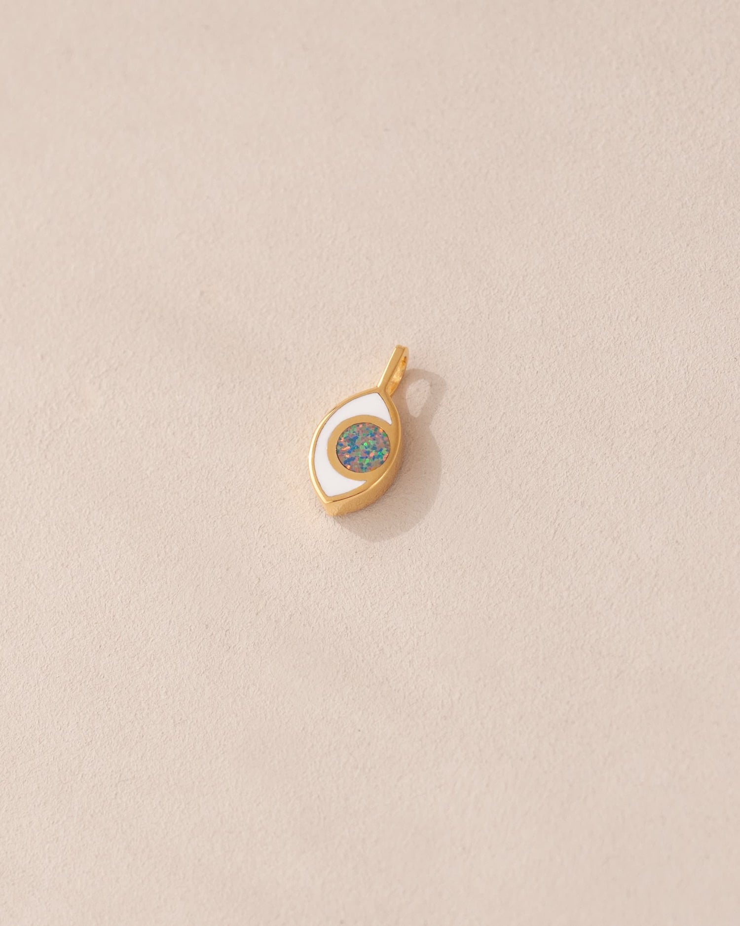 gold eye charm inlaid with dark opal