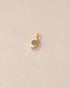 gold eye charm inlaid with dark opal