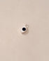 A goldstone charm in the shape of an eye set in a silver setting on a beige background.