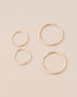 four gold hoops on neutral background