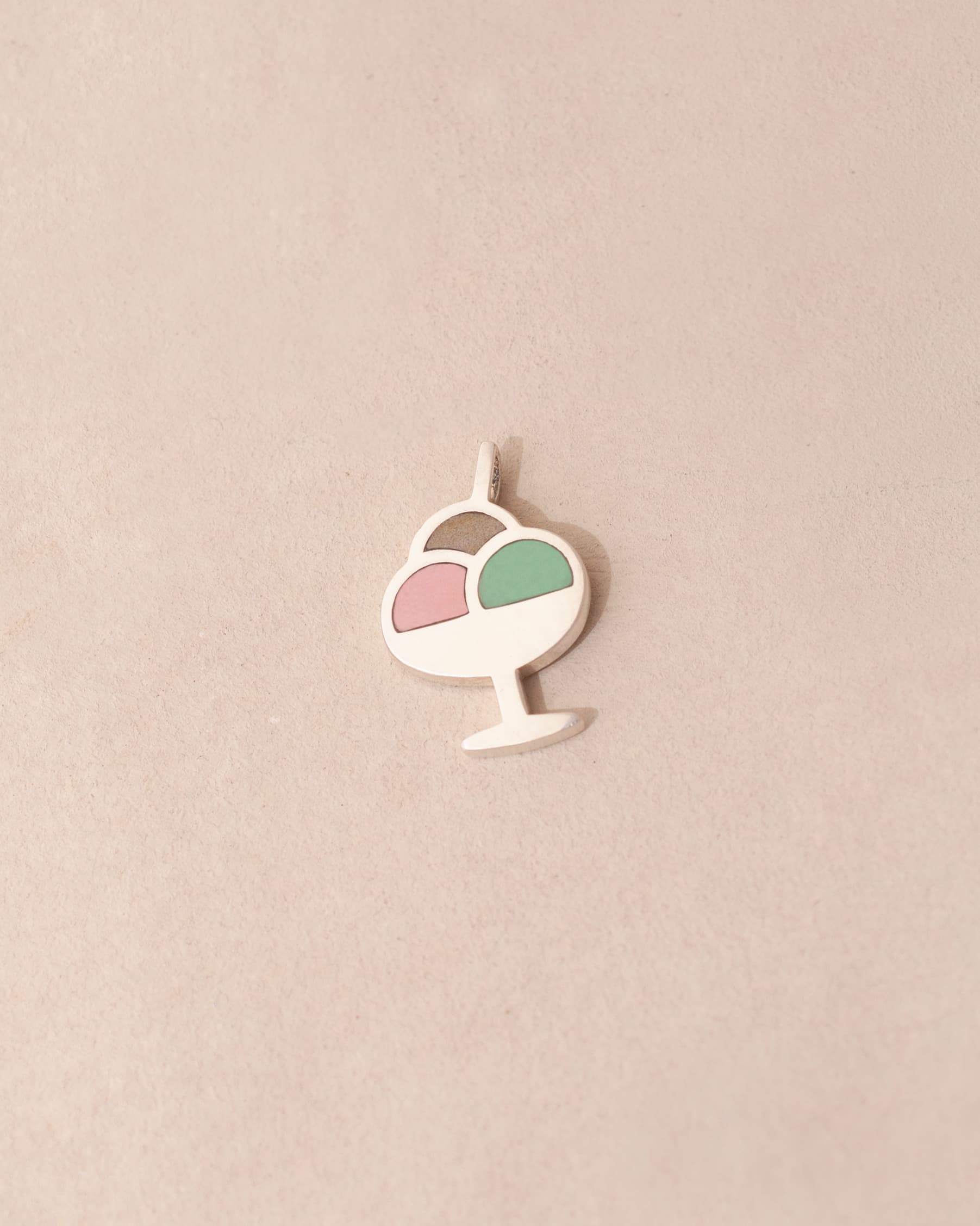 Decorative pendant with a pink and green design on a beige background