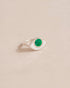 A silver ring with a variscite stone in the shape of an eye, placed on a neutral background.