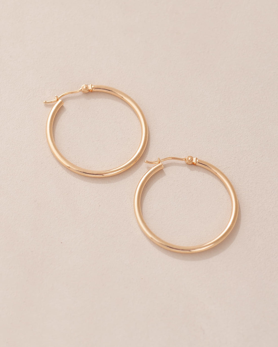 gold hoops on neutral background