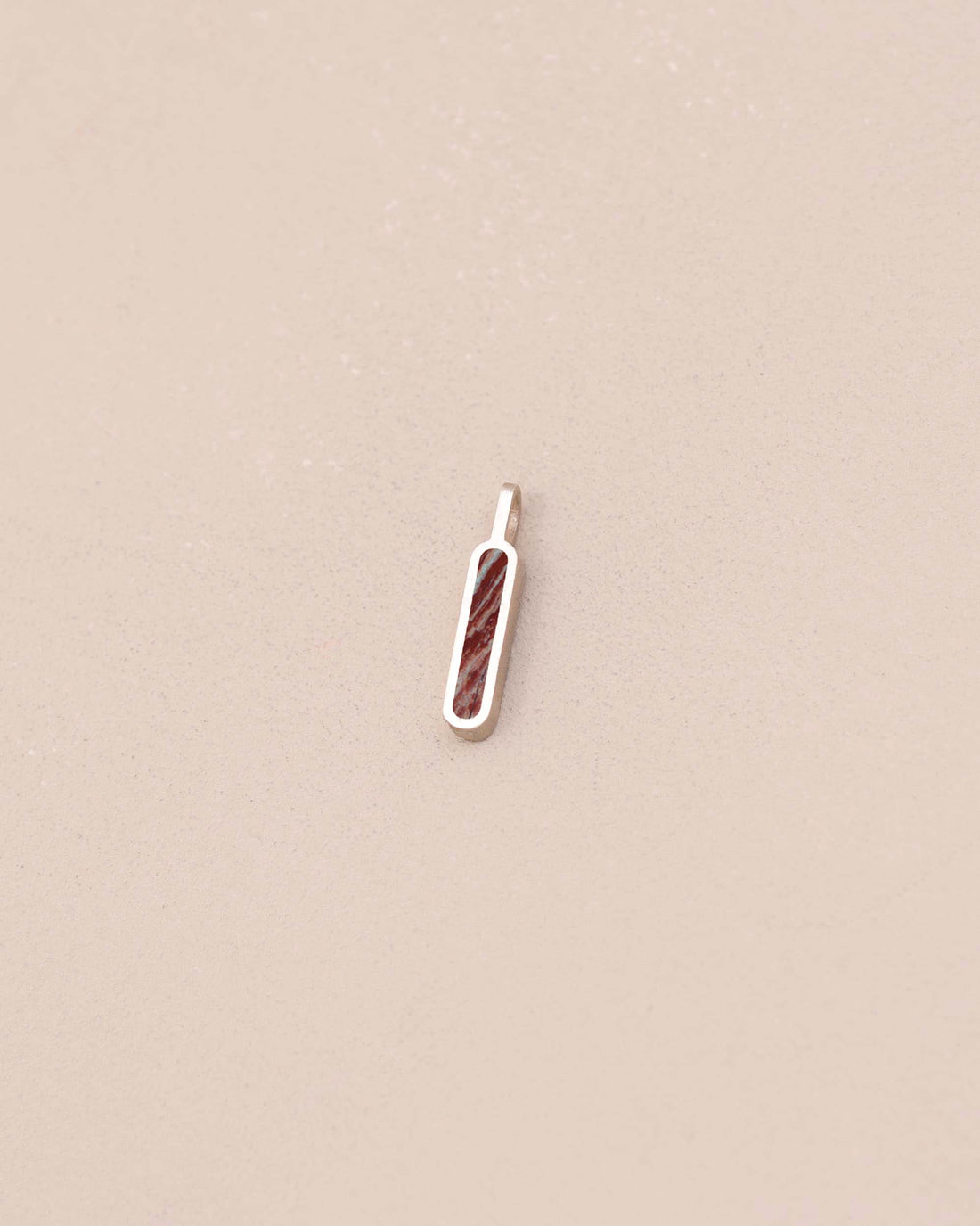 Small pendant with a textured design on a beige background