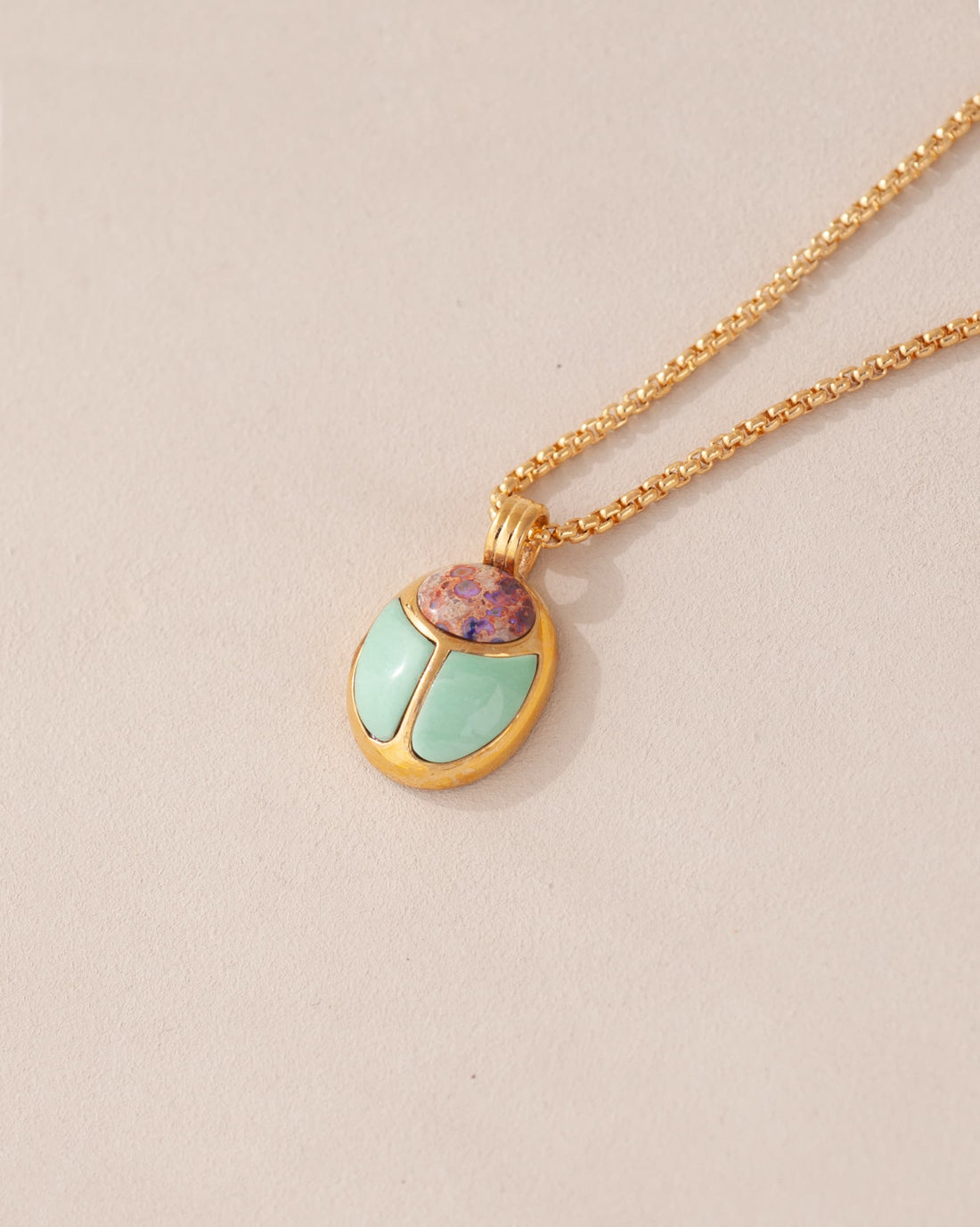 A gold vermeil necklace featuring a scarab amulet with Cantera Opal and Mint Variscite inlays, displayed on a plain background.