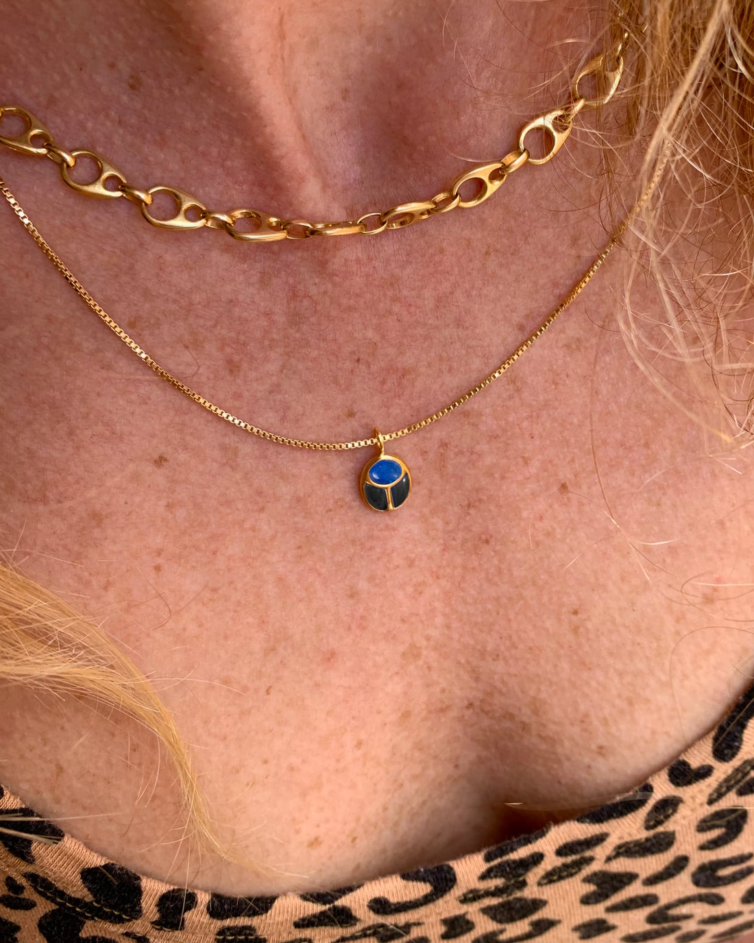 model wearing a scarab charm on a gold chain