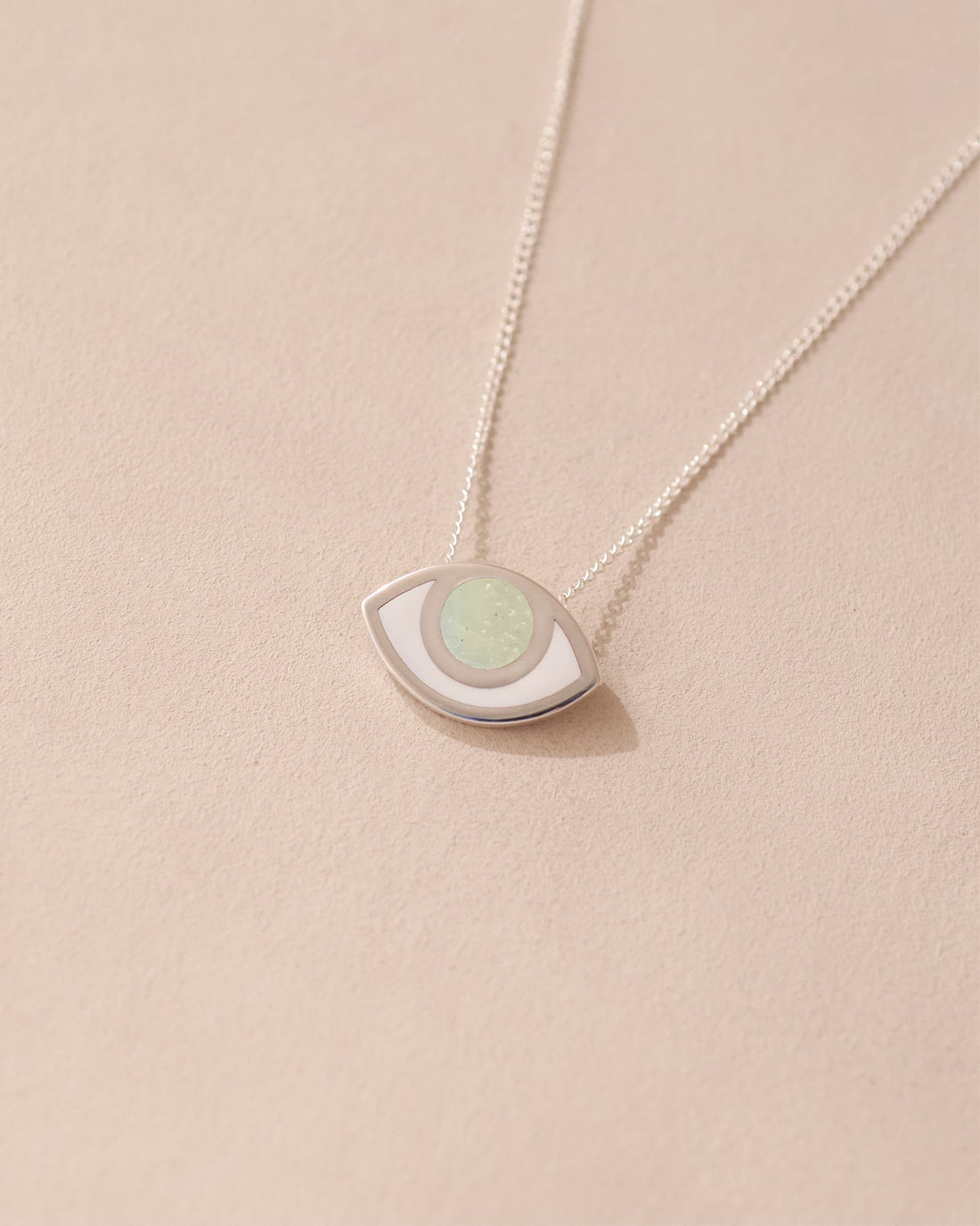 A silver pendant necklace with a round opal stone set in a eye-shaped frame, displayed against a light background.