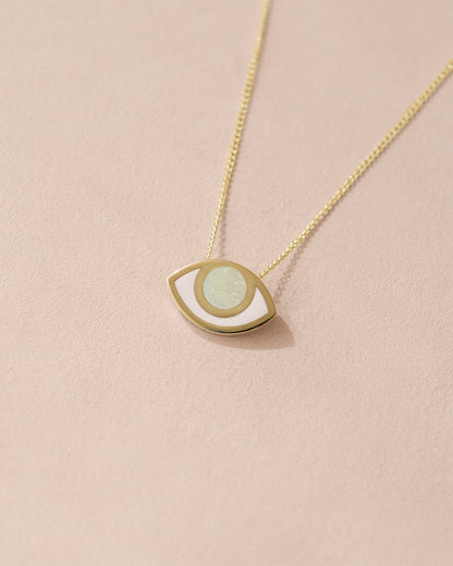 A 14K yellow gold pendant necklace with a UV glow opal eye design on a light background.