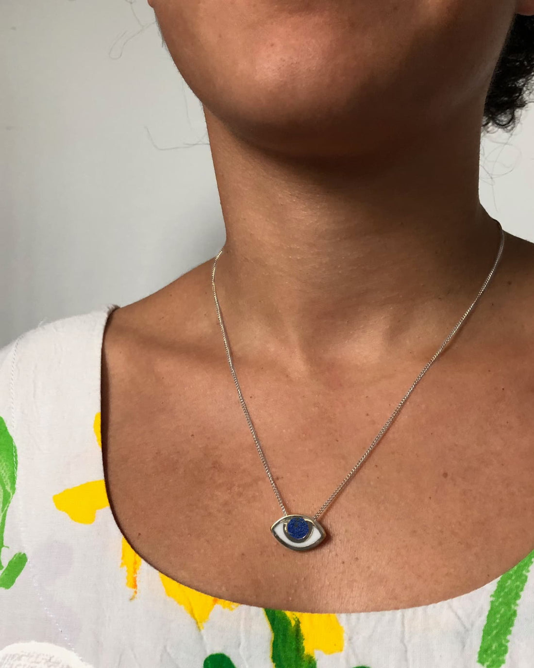 An eye shaped pendant on a model