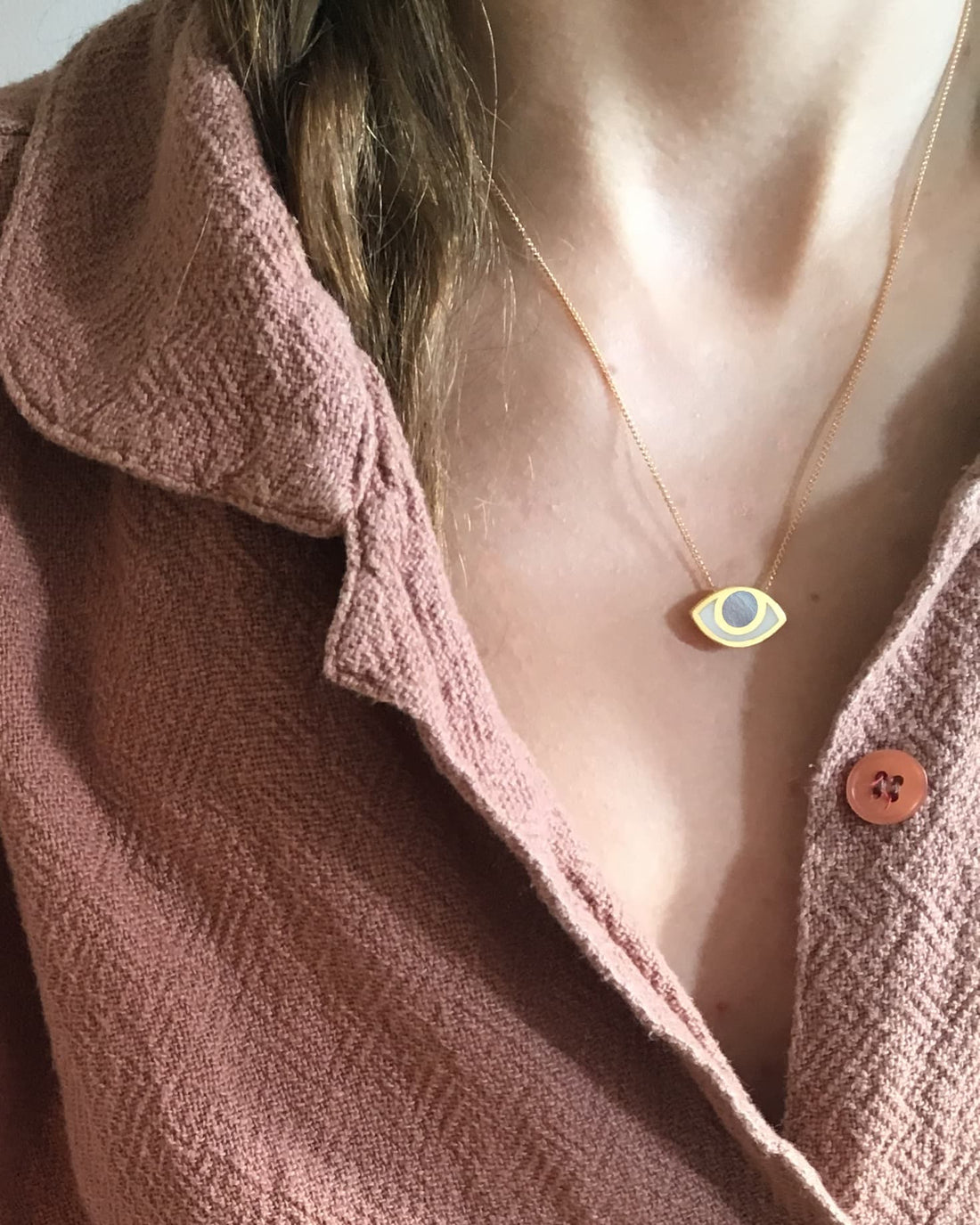 An eye shaped pendant on a model