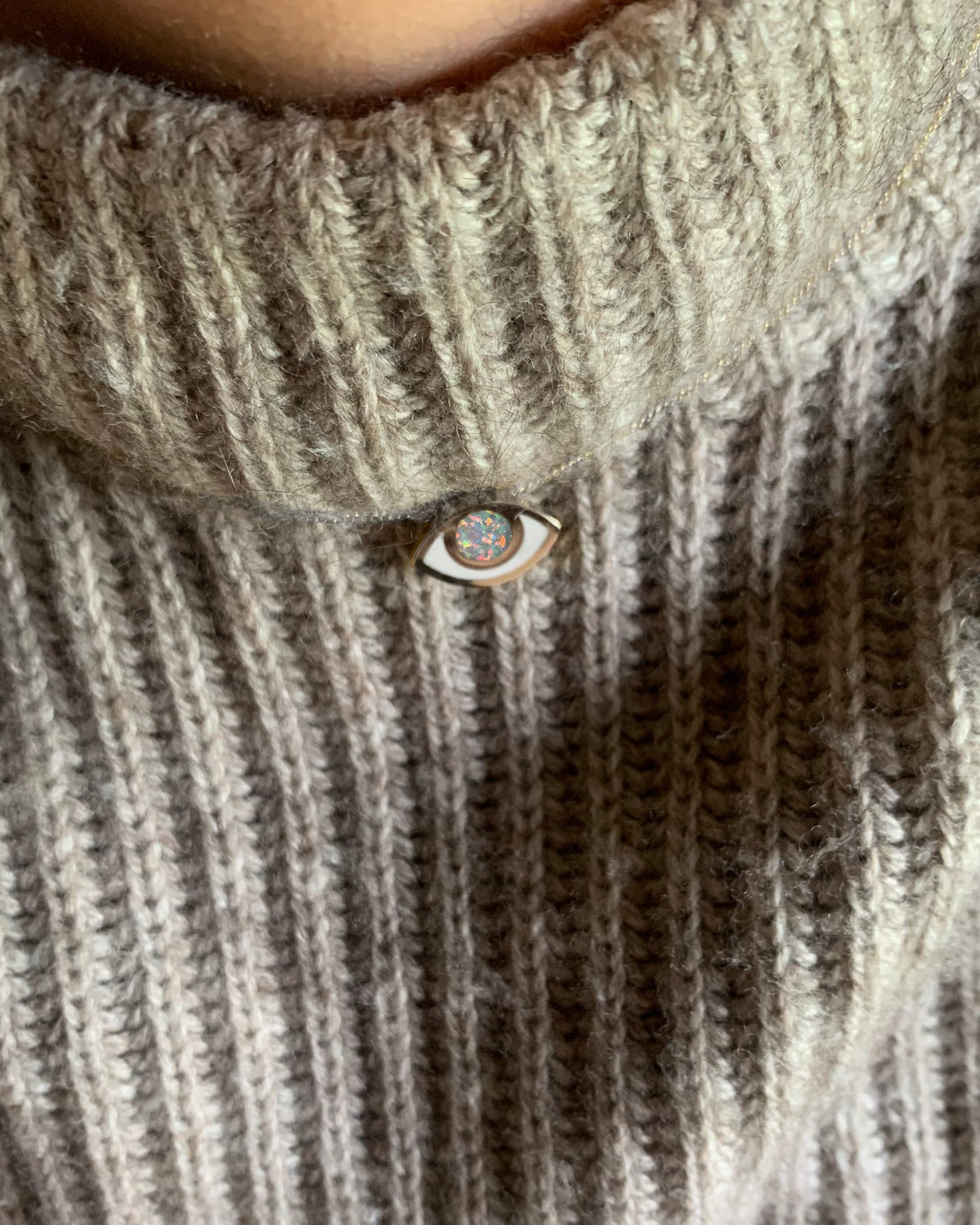 An eye shaped pendant on a model