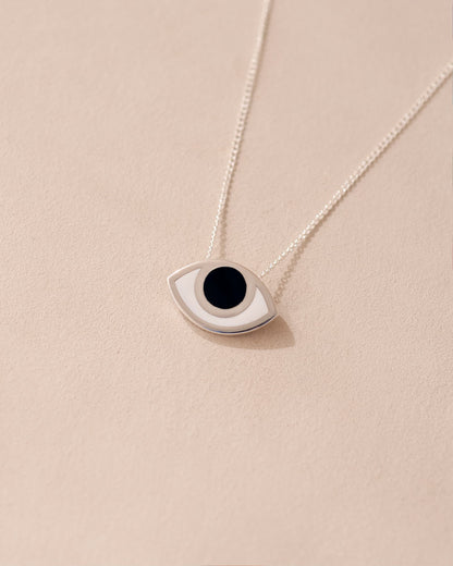 A silver pendant necklace with a onyx stone shaped like an eye, displayed against a light background.