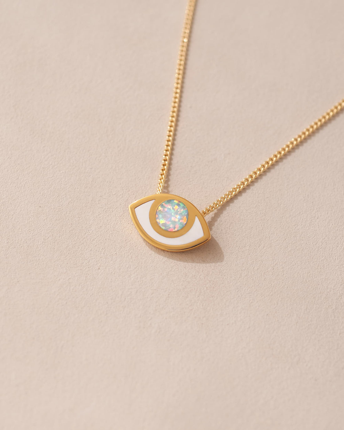 A gold vermeil necklace with a white and gold eye-shaped pendant featuring a jelly opal.