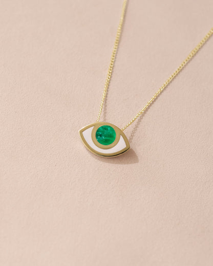 A 14K yellow gold pendant necklace with an eye design featuring a green variscite stone on a beige background.