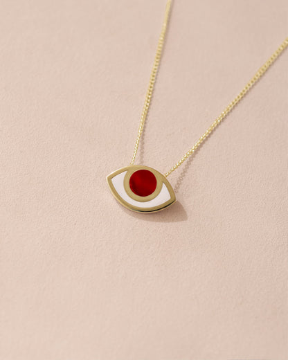 A 14K yellow gold pendant necklace with a carnelian stone shaped as a stylized eye on a chain against a light background.