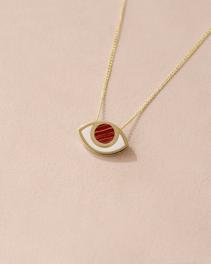 A 14K yellow gold pendant necklace with a red and white snake patterned eye design on a gold chain.