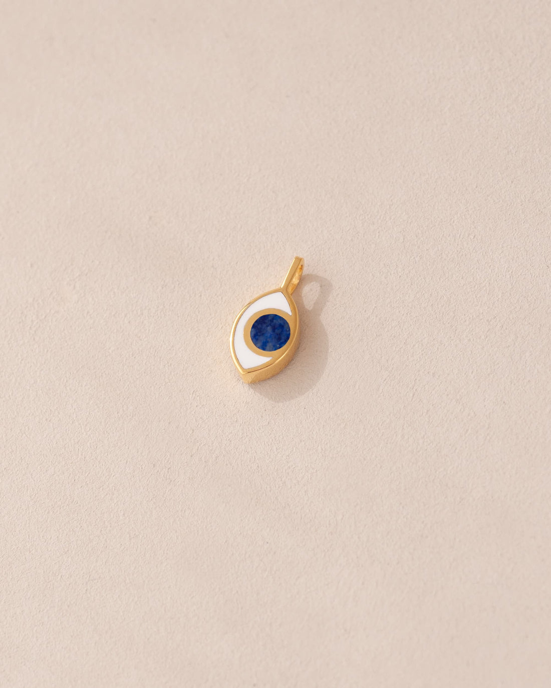 gold charm shaped like an eye with lapis lazuli center