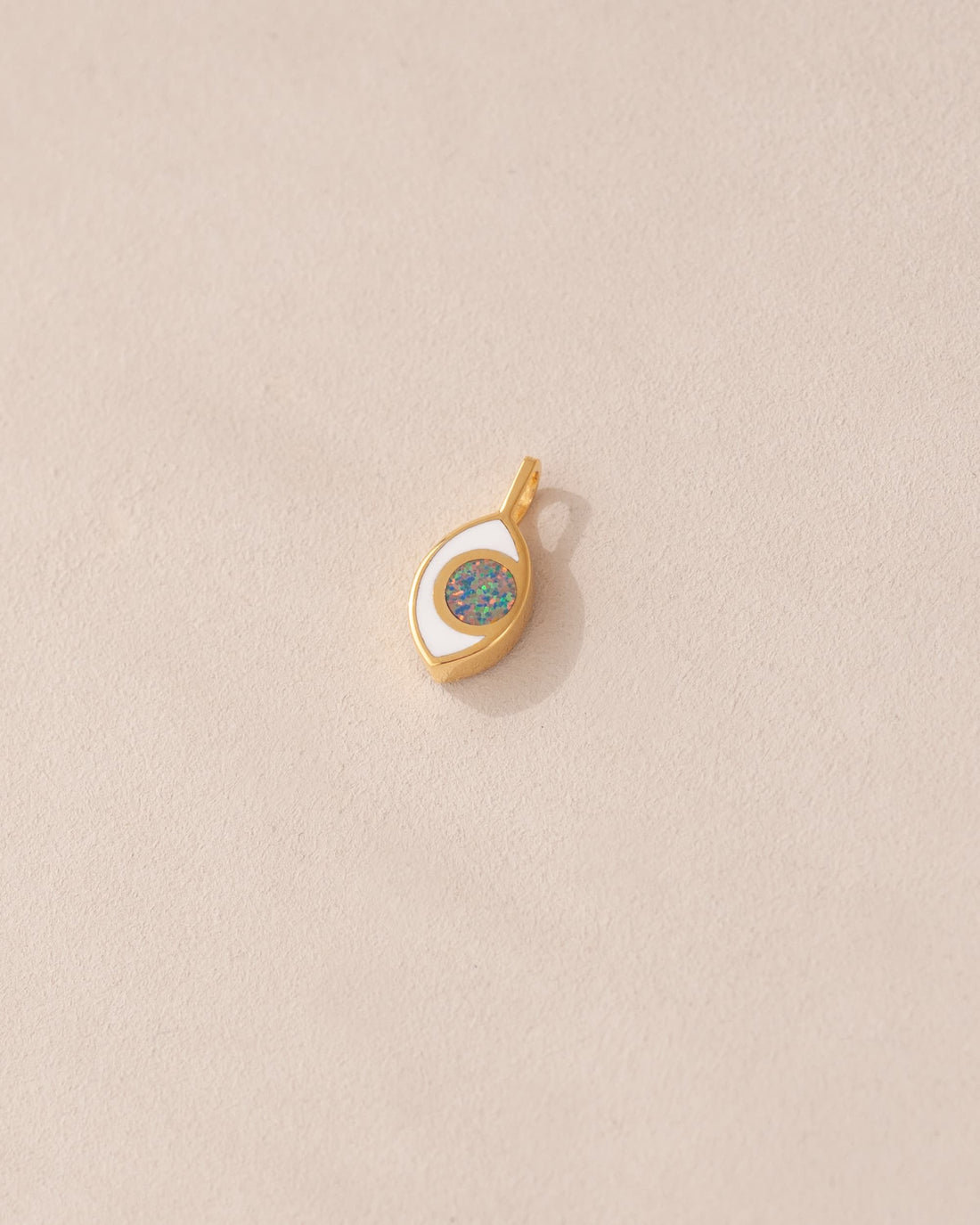 gold eye charm inlaid with dark opal