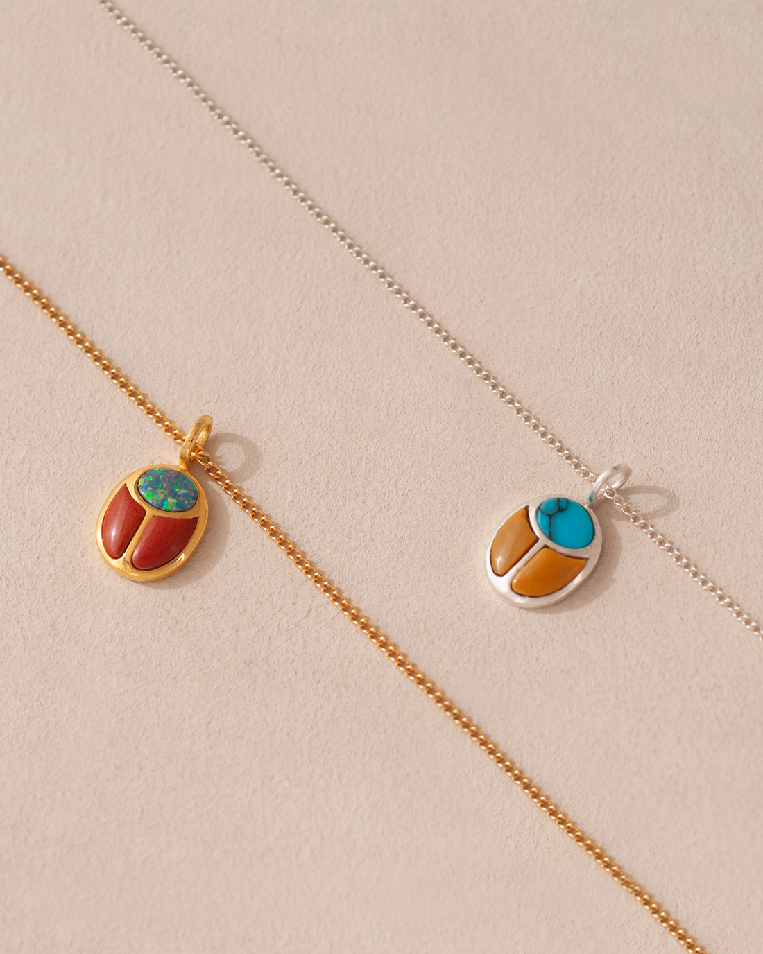 two scarab charms on chains