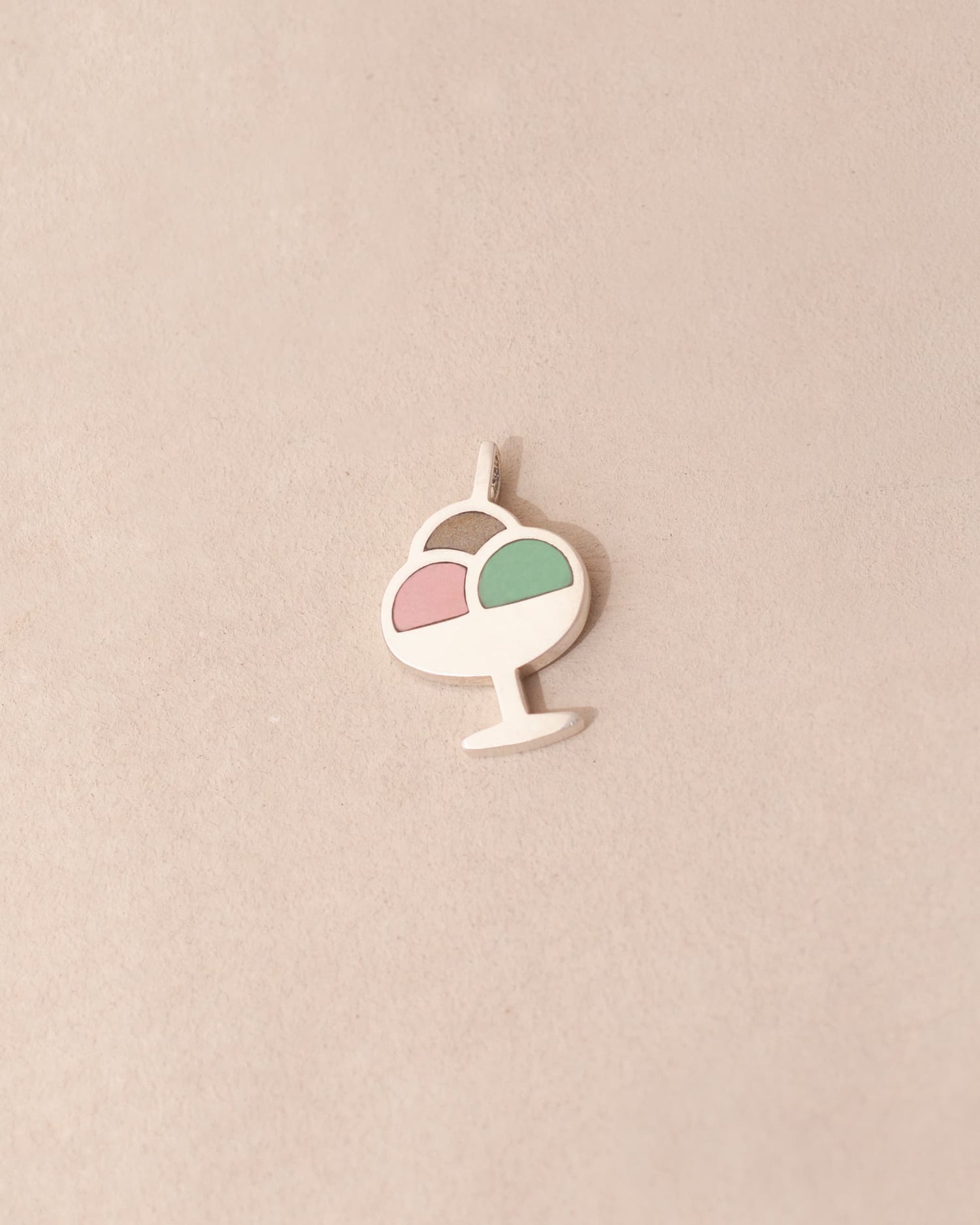 Decorative pendant with a pink and green design on a beige background